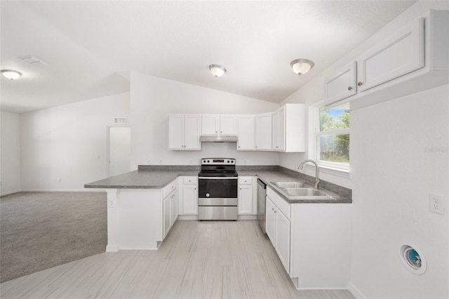 kitchen featuring lofted ceiling, kitchen peninsula, light colored carpet, appliances with stainless steel finishes, and sink