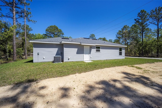 garage with central AC unit and a lawn