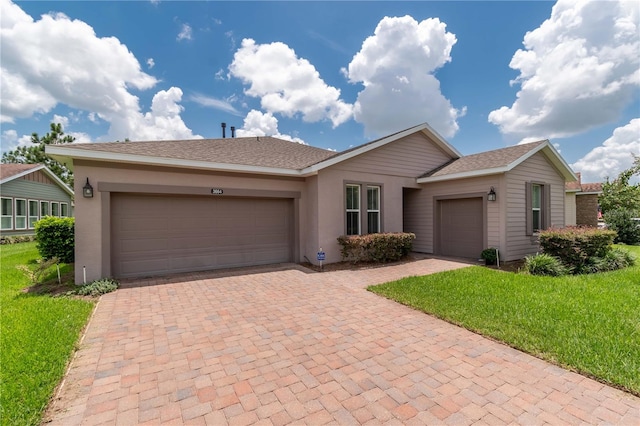 ranch-style house featuring a garage and a front lawn