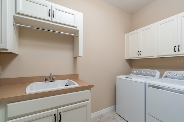 clothes washing area featuring cabinets, light tile patterned floors, separate washer and dryer, and sink