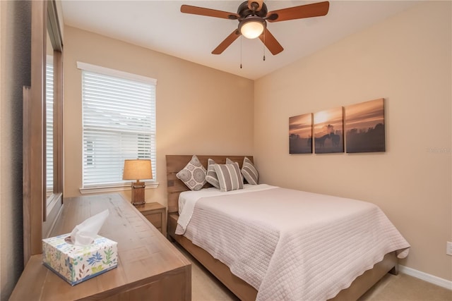 bedroom featuring multiple windows, ceiling fan, and light colored carpet