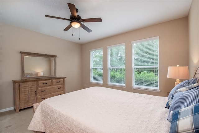 bedroom featuring light colored carpet, multiple windows, and ceiling fan