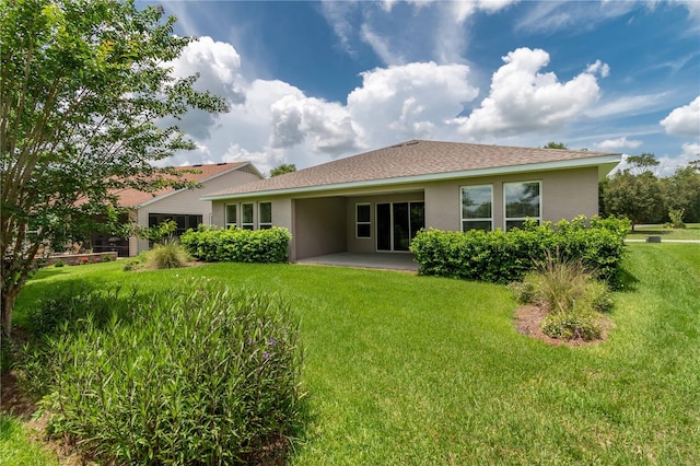 rear view of property with a patio and a lawn