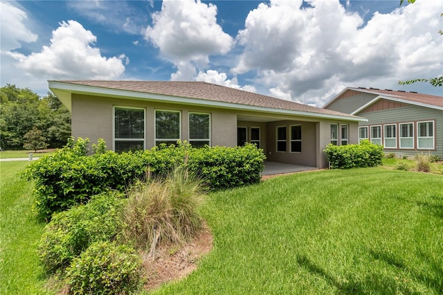 rear view of house with a lawn and a patio area