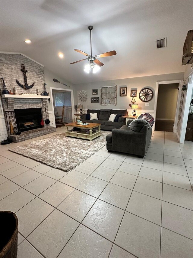 tiled living room featuring brick wall, a fireplace, ceiling fan, and lofted ceiling