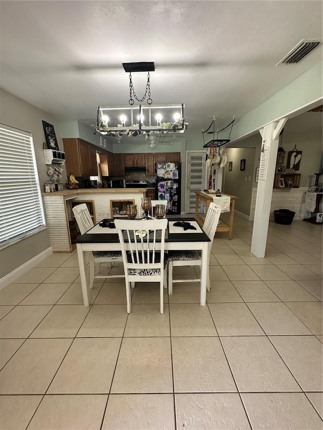 tiled dining room featuring a chandelier