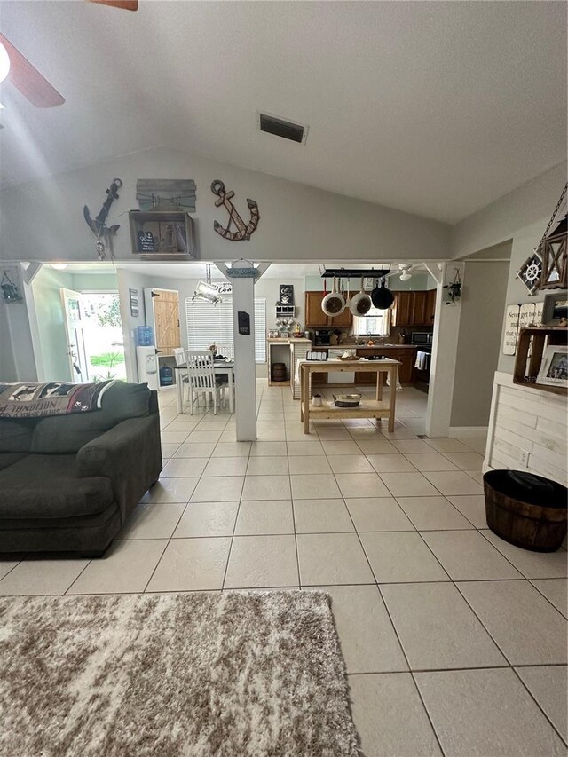 living room with light tile patterned flooring, lofted ceiling, and ceiling fan