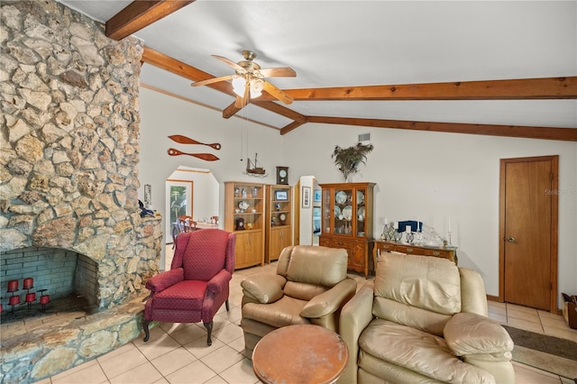 living room featuring light tile patterned flooring, a fireplace, ceiling fan, and vaulted ceiling with beams