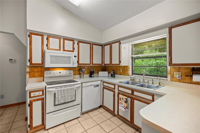 kitchen with light tile patterned flooring, sink, white appliances, and vaulted ceiling