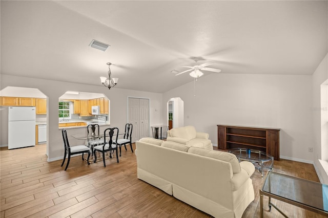 living room featuring lofted ceiling, ceiling fan with notable chandelier, and light wood-type flooring