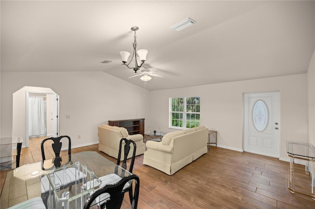 dining room with ceiling fan with notable chandelier, lofted ceiling, and hardwood / wood-style floors