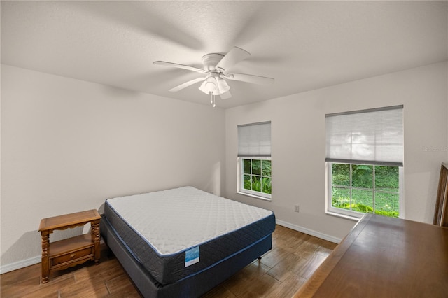 bedroom featuring ceiling fan and dark wood-type flooring