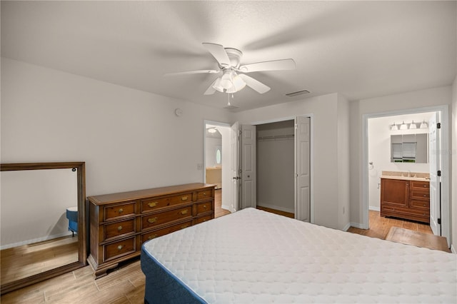 bedroom with light hardwood / wood-style flooring, a closet, ensuite bath, and ceiling fan