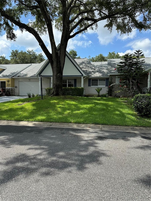 single story home featuring a garage and a front yard