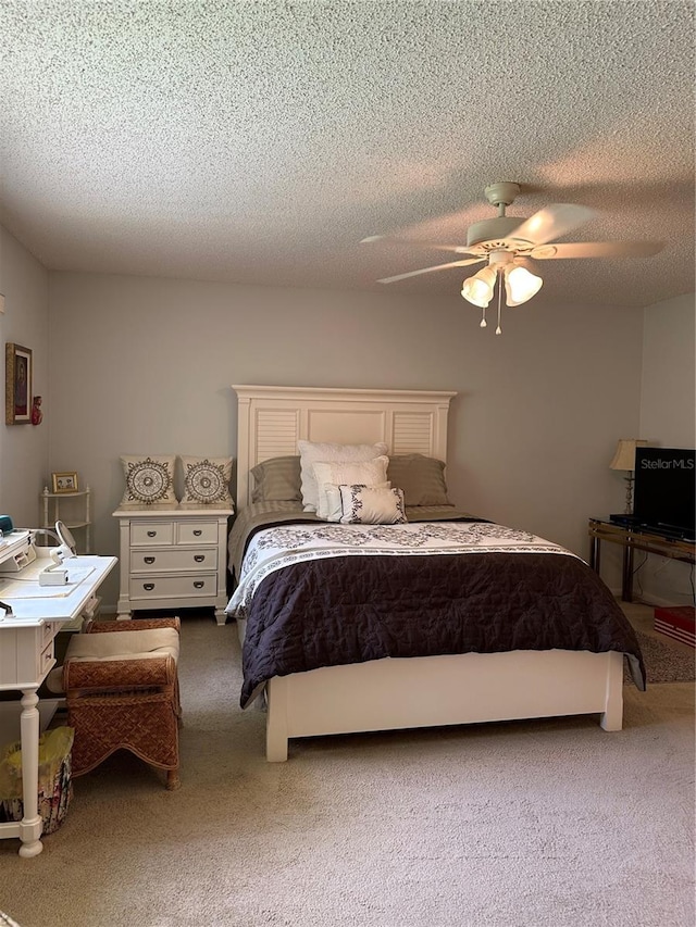 bedroom with a textured ceiling, carpet floors, and ceiling fan