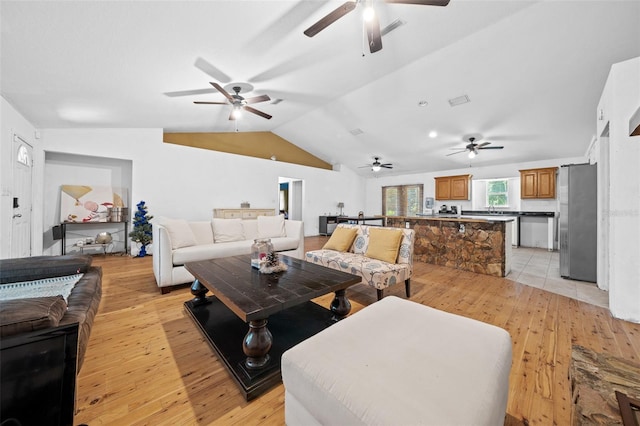 living room featuring ceiling fan, lofted ceiling, and light hardwood / wood-style floors