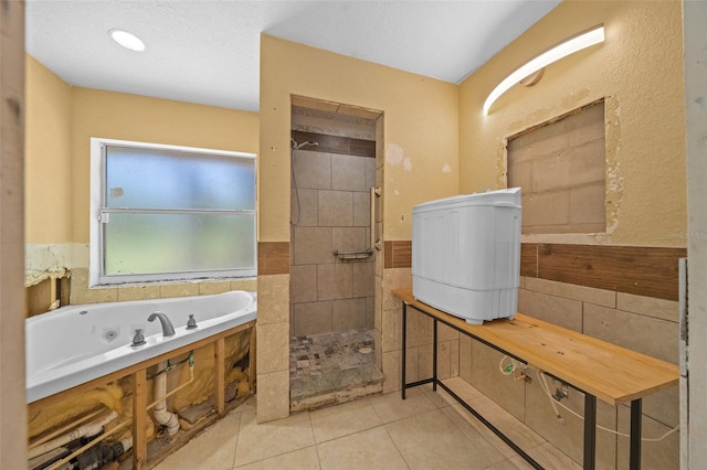 bathroom with a textured ceiling, tile patterned flooring, and separate shower and tub