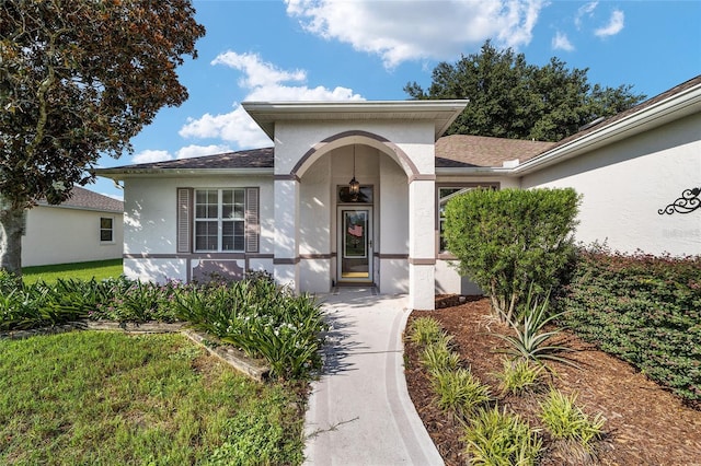 property entrance with a lawn