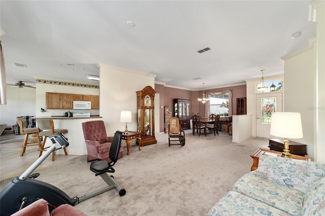 living room with ceiling fan with notable chandelier, light colored carpet, and ornamental molding