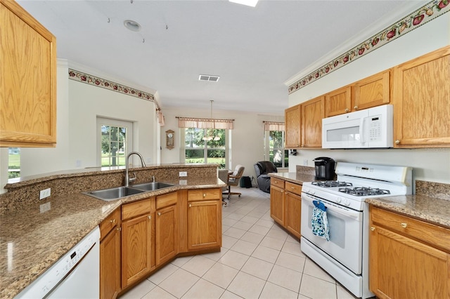 kitchen with light stone countertops, white appliances, sink, kitchen peninsula, and ornamental molding