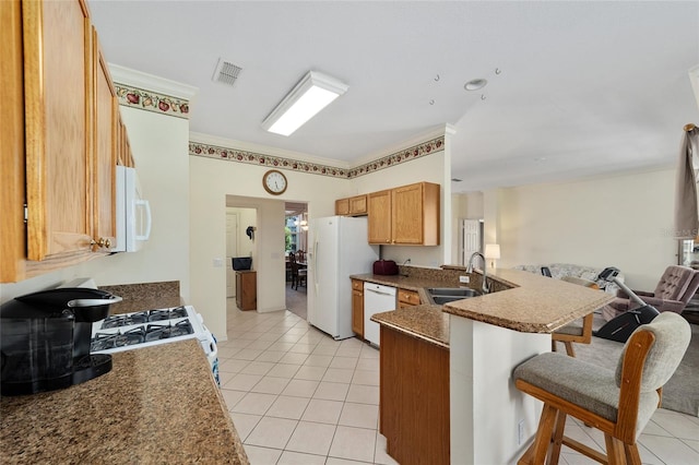 kitchen with light tile patterned flooring, sink, kitchen peninsula, and white appliances