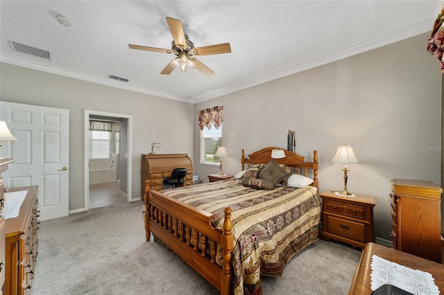 bedroom with ceiling fan, light colored carpet, multiple windows, and ensuite bathroom