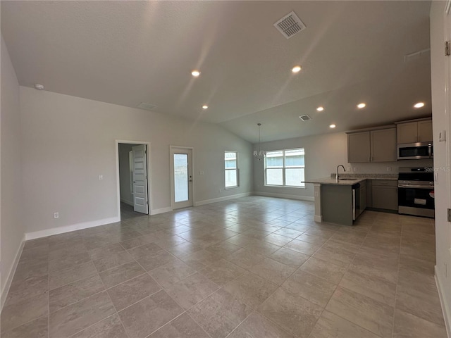 unfurnished living room featuring a sink, visible vents, lofted ceiling, and baseboards