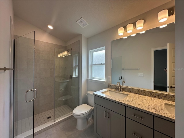 bathroom with visible vents, a shower stall, toilet, double vanity, and a sink