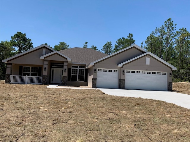 view of front of home featuring a front lawn, a porch, and a garage