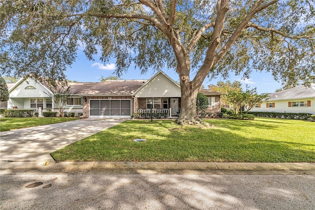 single story home featuring brick siding, a porch, an attached garage, a front yard, and driveway