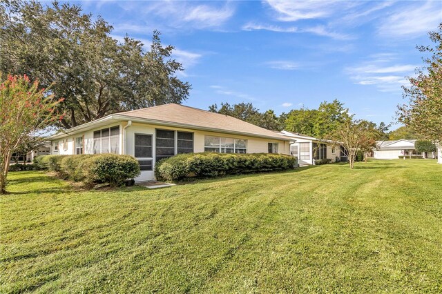 view of side of home with a yard