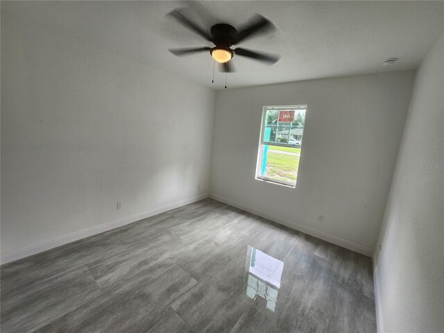 spare room featuring ceiling fan and dark hardwood / wood-style flooring