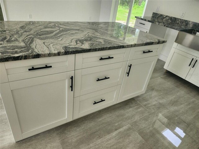 kitchen featuring dark stone counters and white cabinets