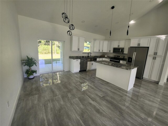 kitchen with white cabinetry, hanging light fixtures, a kitchen island, high vaulted ceiling, and appliances with stainless steel finishes