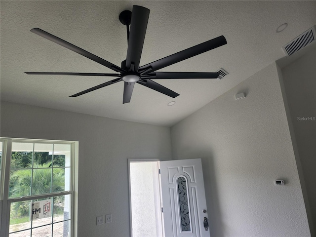 room details with ceiling fan and a textured ceiling