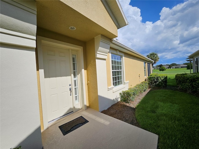 doorway to property with a lawn