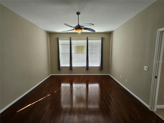 unfurnished room with ceiling fan, dark wood-type flooring, and a textured ceiling