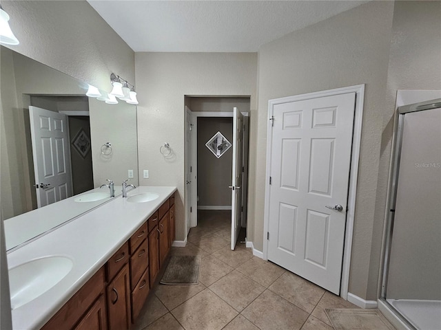 bathroom featuring vanity, tile patterned floors, and a shower with shower door