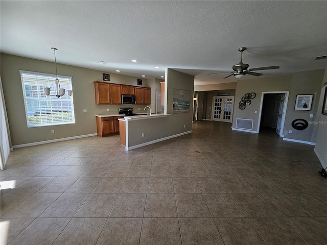 kitchen with black range with electric cooktop, tile patterned floors, a textured ceiling, decorative light fixtures, and ceiling fan with notable chandelier