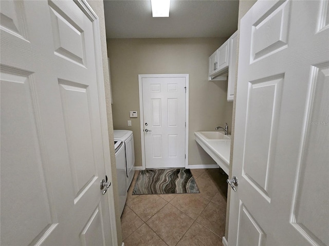 washroom featuring washer and dryer, cabinets, light tile patterned floors, and sink