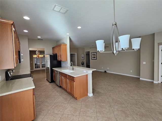 kitchen with pendant lighting, sink, kitchen peninsula, stainless steel appliances, and a chandelier