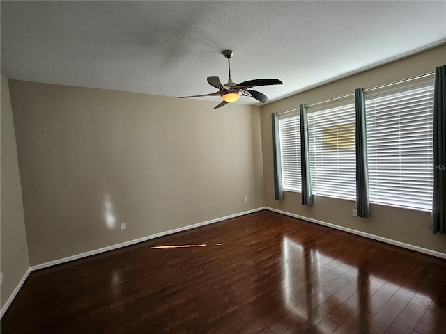 unfurnished room with ceiling fan, dark hardwood / wood-style flooring, and a textured ceiling