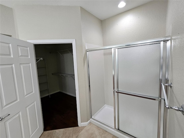 bathroom featuring tile patterned floors and a shower with shower door