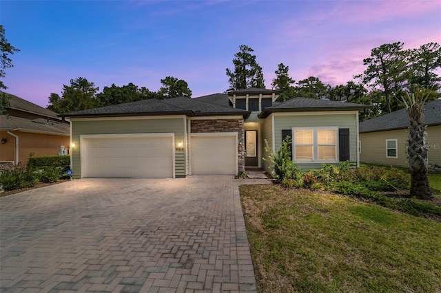 prairie-style home featuring a garage and a yard