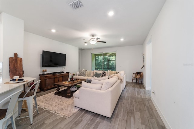 living room featuring ceiling fan and hardwood / wood-style flooring