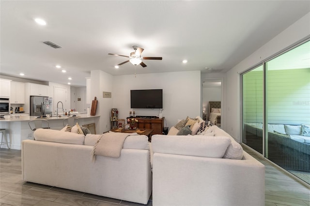 living room with ceiling fan and sink