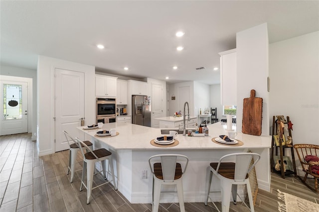 kitchen with a wealth of natural light, stainless steel appliances, kitchen peninsula, and a breakfast bar