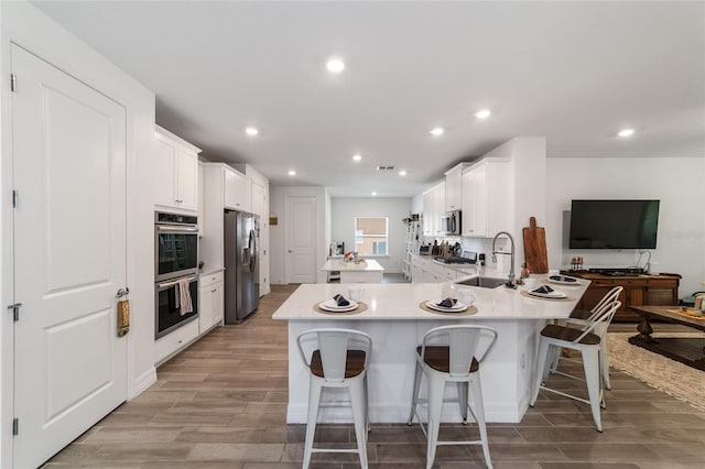 kitchen featuring kitchen peninsula, appliances with stainless steel finishes, sink, and a breakfast bar area