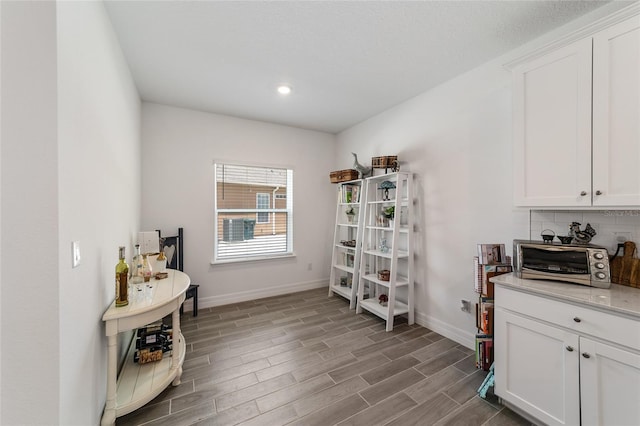 interior space featuring white cabinets and tasteful backsplash