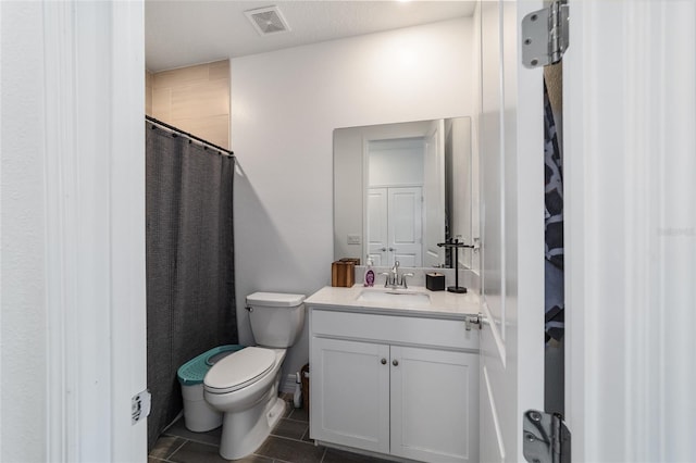 bathroom featuring toilet, tile patterned flooring, vanity, and curtained shower